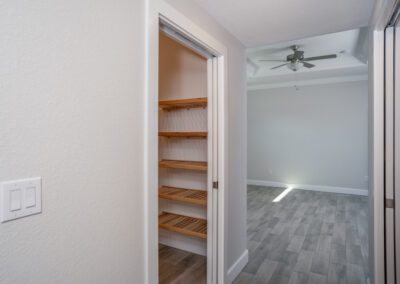A medium sized storage closet adjoining a hallway.
