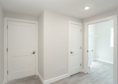 A hallways with a closet and two adjoining rooms
