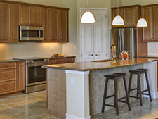 A large kitchen with center island and brown cabinets.
